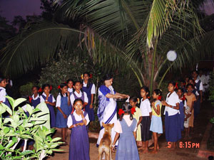 Anitaben distributing prasadam after evening Prayers